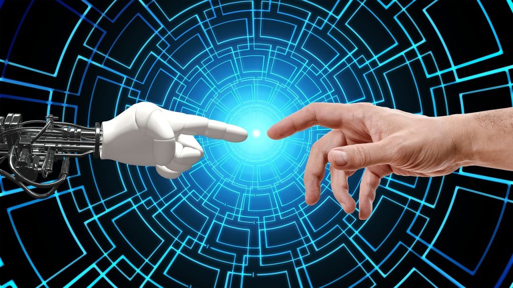 Mano umana che tocca mano di robot, simboleggia l'unione tra persone e intelligenza artificiale